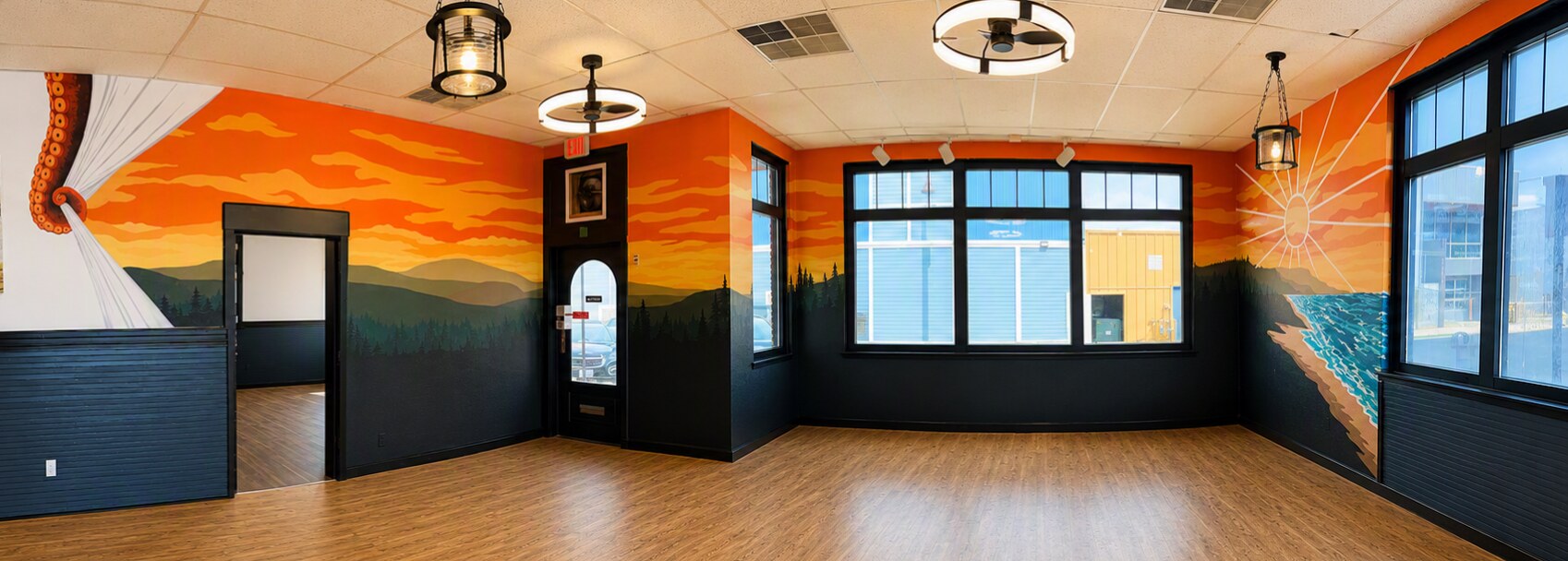 Panoramic view of the hand-painted Claim 52 Newport taproom mural, sunset over mountains and coastline